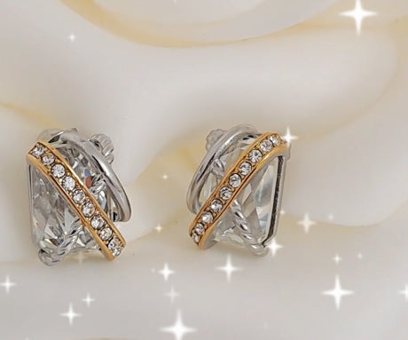 Detalhe dos brincos elegantes com zircónia central e acabamento prateado dourado