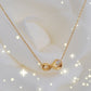 Detalhe do pingente infinito dourado com zircónias brilhantes, design moderno