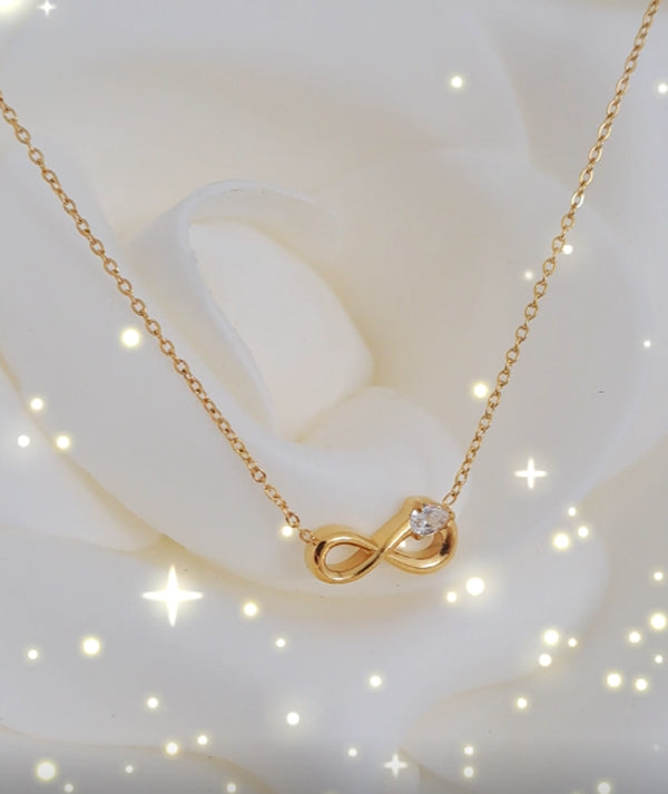 Detalhe do pingente infinito dourado com zircónias brilhantes, design moderno